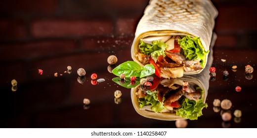 Two Burrito, Black And White Lavash With Chicken, Mushrooms, Salad, Cherry Tomatoes, Lime, And Salsa. Copy Space, Selective Focus