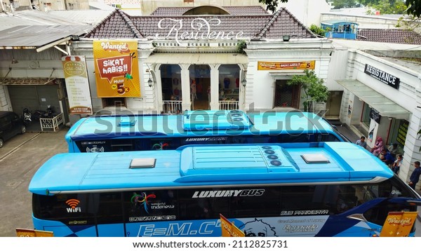 Two buses are parked in a\
shopping area on Jalan Cihampelas 26 January 2022, West Java,\
Indonesia