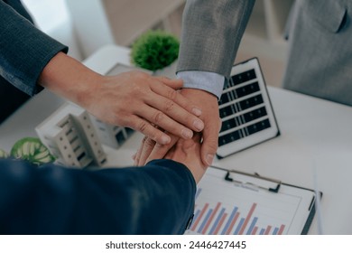 Two business executives, elegantly attired in suits, join hands in a gesture of unity, solidarity, and shared commitment towards a common goal or venture. - Powered by Shutterstock