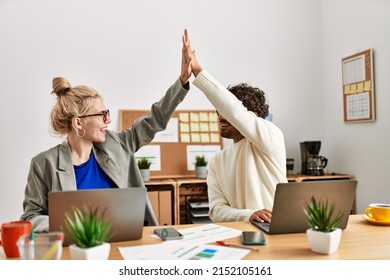 Two business executives raised up hands hitting five at the office. - Shutterstock ID 2152105161