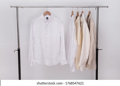 Two Business Formal Linen Suit And Polo Shirt And White Long Sleeved Shirt On Hanger
