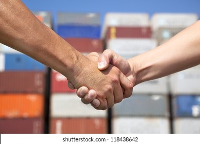 two business man handshaking before stack of containers