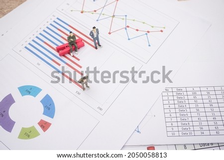 Two of business man miniature with flow linear graph, bar graph. Concepts about increasing business compare with economic growth