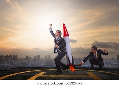 Two Business Man Playing Rocket Toy On High Building Roof With Sky Scraper Background Abstract For Successful Business Partner