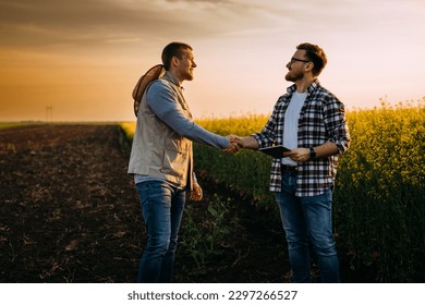 Two business man shake hands on a field. - Powered by Shutterstock