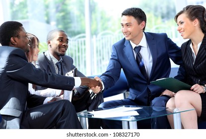 Two Business Man Shaking Hands With His Team In Office