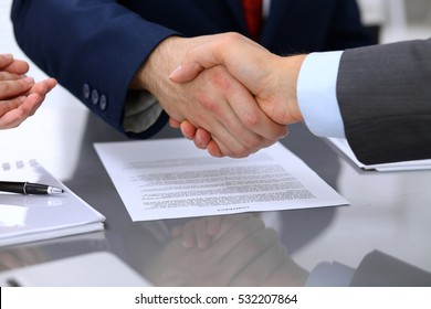 Two business man shaking hands to each other above signed contract - Shutterstock ID 532207864