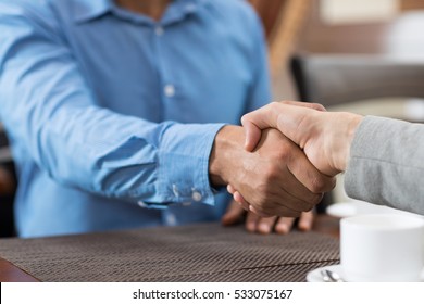 Two Business Man Sitting At Table Cafe Closeup Coffee Break Meeting, Businessman Hand Shake Agreement - Powered by Shutterstock