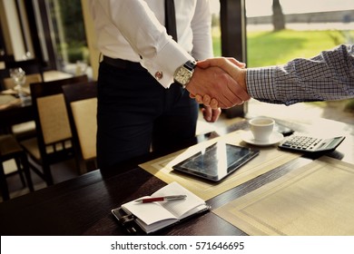 Two Business Man Sitting At Table Cafe Closeup Coffee Break Meeting, Businessman Hand Shake Agreement - Powered by Shutterstock