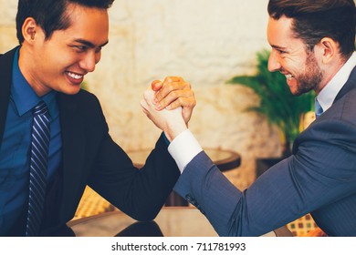 Two Business Men Arm Wrestling Stubbornly in Lobby