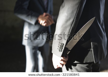 two business men making a deal but hiding knives