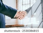 Two business men shaking hands in a business setting. Handshake, agreement, partnership, and cooperation. Business men shake hands making business deal and agreement in modern office.