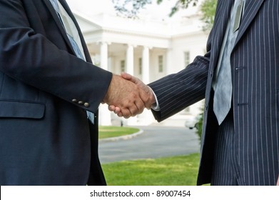 Two business men shaking hands in front of the White House in Washington DC