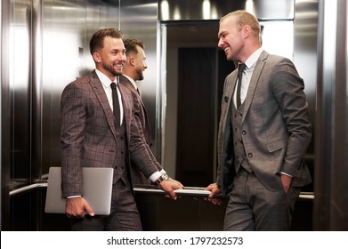 two business partners in elevator, after meeting, they solved economic problems. business cooperation concept