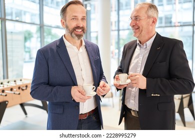 Two business people and colleagues in a coffee break with casual small talk - Powered by Shutterstock