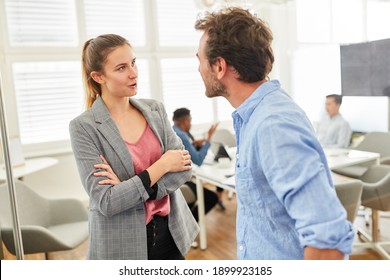 Two business people in dialogue or having relaxed small talk in the office