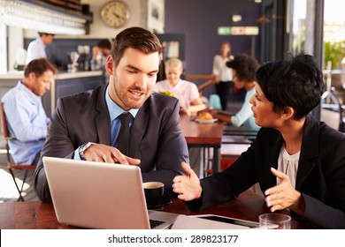 Two Business People With Laptop Meeting In A Coffee Shop