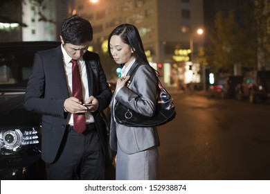 Two Business People Looking At Cell Phone