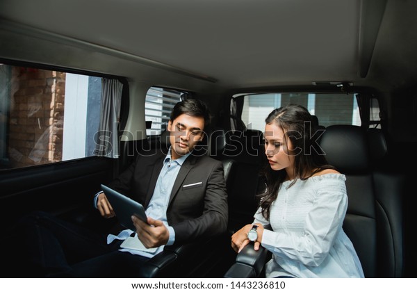 two\
business people meeting while sitting on passenger seat of car.\
modern business team on their way for\
meeting
