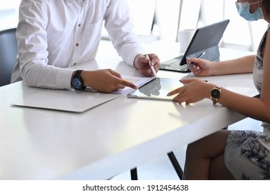 Two Business People In Protective Mask Using Digital Tablet And Working Together On New Project At Modern Office.