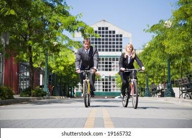 Two business people riding bicycle to work, can be used for gas savings concept