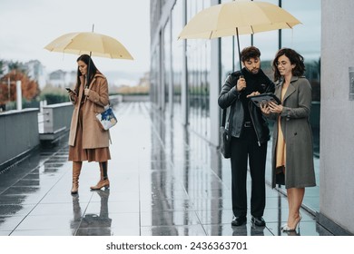 Two business people sharing a tablet under a yellow umbrella on a rainy city street, with a woman walking in the background. - Powered by Shutterstock