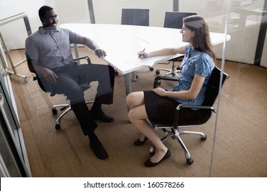 Two Business People Sitting At Conference Table And Discussing During Business Meeting