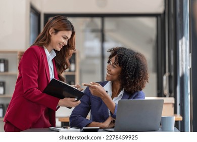 Two business people talk project strategy at office meeting room. Businessman discuss project planning with colleague at modern workplace while having conversation and advice on financial data report. - Shutterstock ID 2278459925