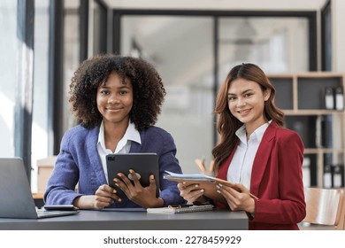 Two business people talk project strategy at office meeting room. Businessman discuss project planning with colleague at modern workplace while having conversation and advice on financial data report. - Shutterstock ID 2278459929