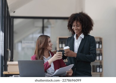 Two business people talk project strategy at office meeting room. Businessman discuss project planning with colleague at modern workplace while having conversation and advice on financial data report. - Shutterstock ID 2278696099