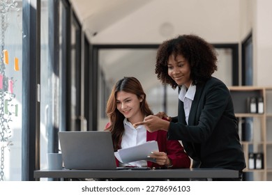 Two business people talk project strategy at office meeting room. Businessman discuss project planning with colleague at modern workplace while having conversation and advice on financial data report. - Shutterstock ID 2278696103