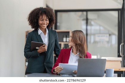 Two business people talk project strategy at office meeting room. Businessman discuss project planning with colleague at modern workplace while having conversation and advice on financial data report. - Shutterstock ID 2278696129