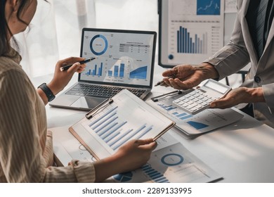 Two business people talk project strategy at office meeting room. Businessman discuss project planning with colleague at modern workplace while having conversation and advice on financial data report. - Powered by Shutterstock