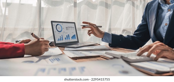 Two business people talk project strategy at office meeting room. Businessman discuss project planning with colleague at modern workplace while having conversation and advice on financial data report - Shutterstock ID 2295415755