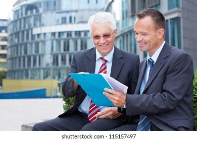 Two Business People Talking About A Contract Outside