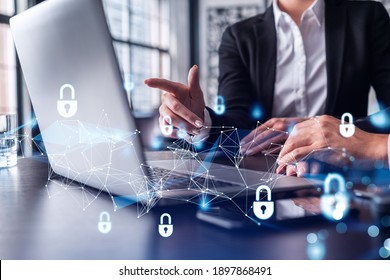Two business people working on the project to protect cyber security of international company using laptop. Padlock Hologram icons. Teamwork concept. - Shutterstock ID 1897868491