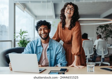 Two business people working on creative projects in a modern office. Focused on work, they demonstrate successful teamwork.This dynamic team strives for success in their startup. - Powered by Shutterstock