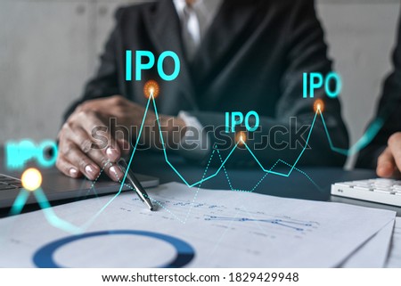 Two business people working together on white paper to release and present IPO project to investors. Initial primary offering hologram. Double exposure.