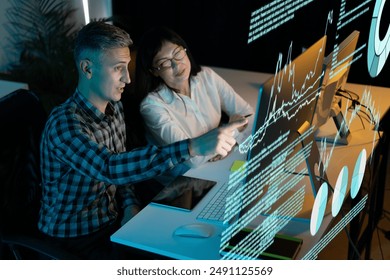 Two Business Professionals Analyzing Data On Computer Screens, Discussing Growth Strategies. The Scene Reflects Modern Workplace Collaboration, Innovation, 