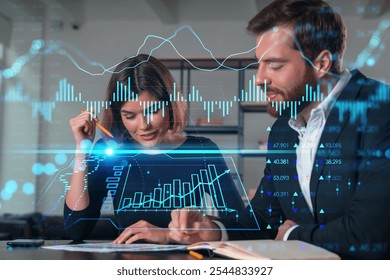 Two business professionals analyzing data with digital financial charts overlayed, in an office environment. Concept of business analysis - Powered by Shutterstock