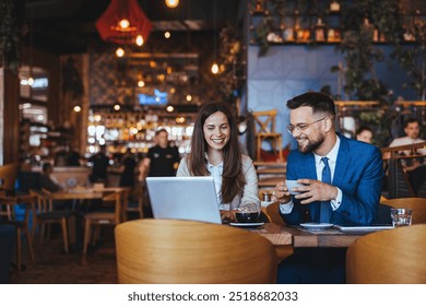 Two business professionals engage in a lively meeting at a modern café. The atmosphere is vibrant and collaborative, fostering creativity and teamwork. - Powered by Shutterstock