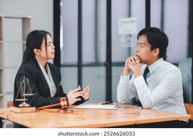 Two business professionals engaged in a serious discussion about legal matters in a modern office environment. - Powered by Shutterstock