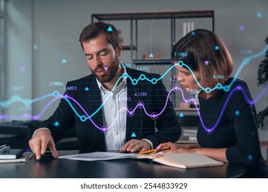 Two business professionals evaluating documents with digital data graphs overlay. Office background. Concept of finance analysis - Powered by Shutterstock