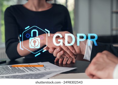 Two business professionals shaking hands with a GDPR lock icon overlay. Modern office background. Concept of data protection and privacy policy - Powered by Shutterstock