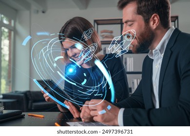 Two business professionals using digital devices with futuristic holographic interface overlays in a modern office setting, concept of innovation and technology integration - Powered by Shutterstock