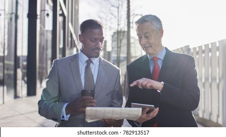 Two Business Professionals Walking And Discussing News