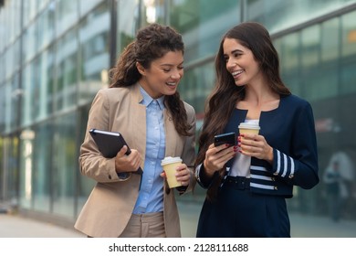 Two Business Woman Holding Cup Of Coffee And Looking At The Phone