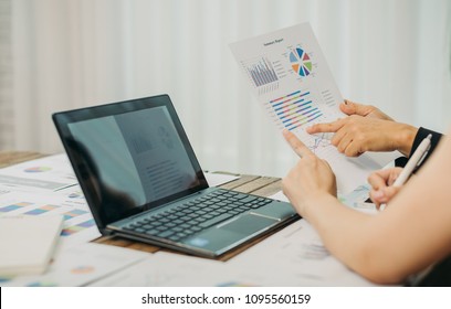 Two business woman investment consultant analyzing company annual financial report balance sheet statement working with documents graphs. Concept picture of economy, market, office,money and tax.
