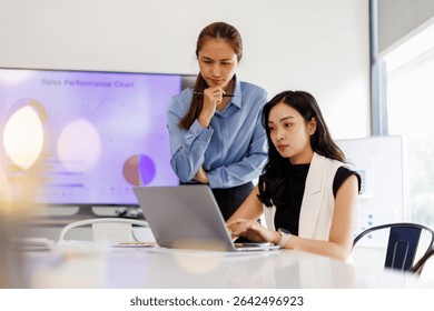  Two business woman lawyer or company employee holding accounting bookkeeping documents checking financial data or marketing report working in office with laptop. Paperwork management
