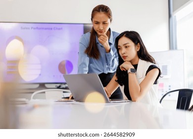  Two business woman lawyer or company employee holding accounting bookkeeping documents checking financial data or marketing report working in office with laptop. Paperwork management
